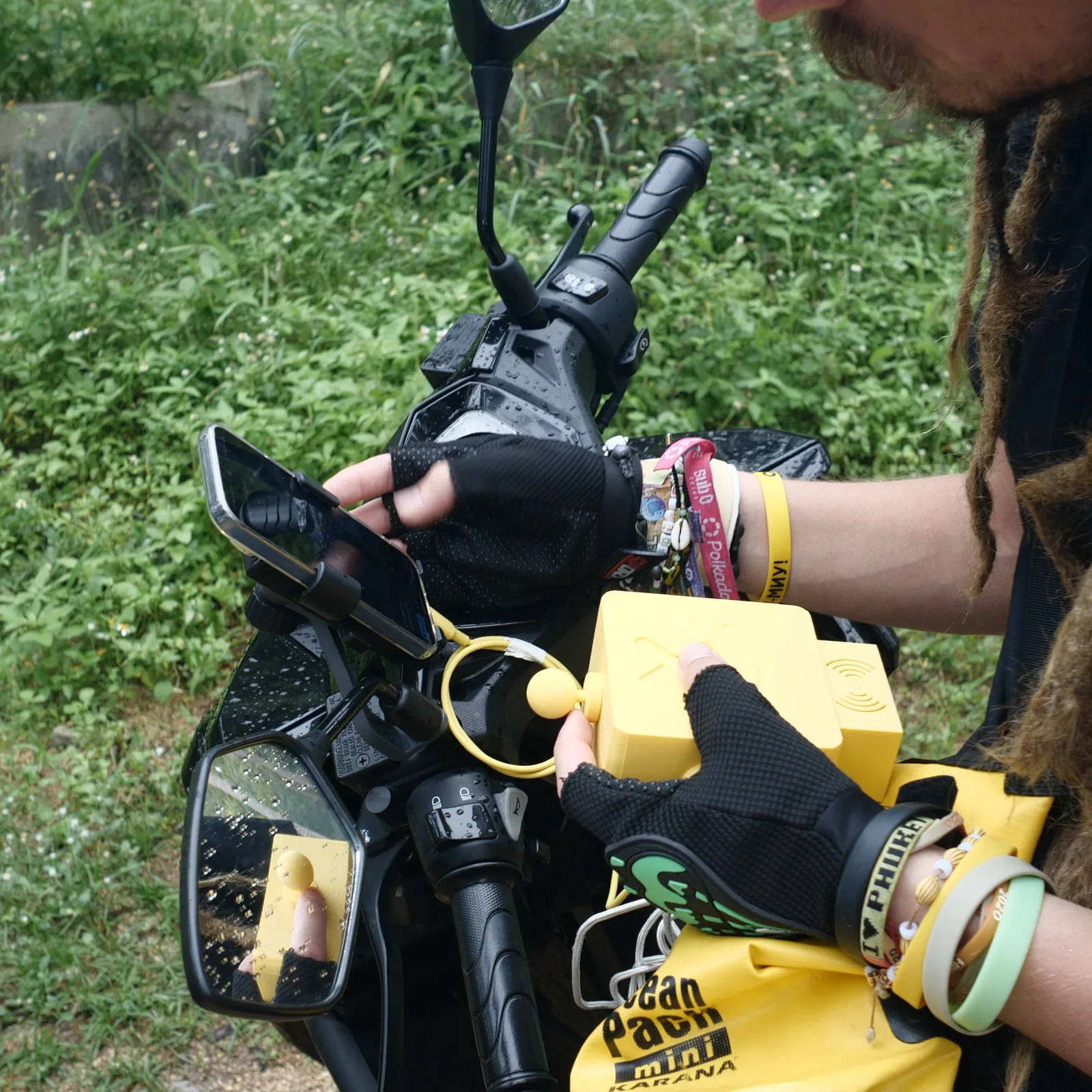 A yellow Altruist clipped to the handlebar of a scooter in the rain